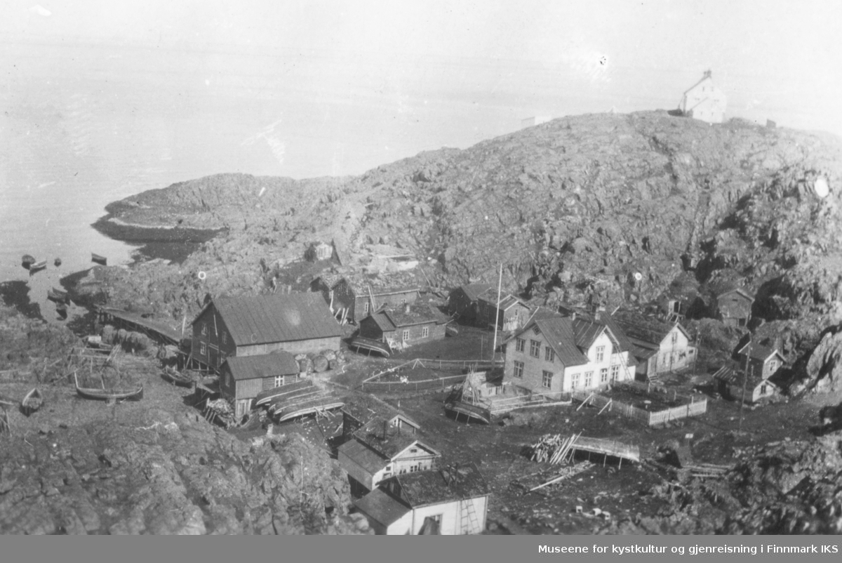 Helnes med bebyggelsen, båter som ligger på land, fiskehjeller og på toppen t.h. ser man Helnes fyr. 1910-1944.