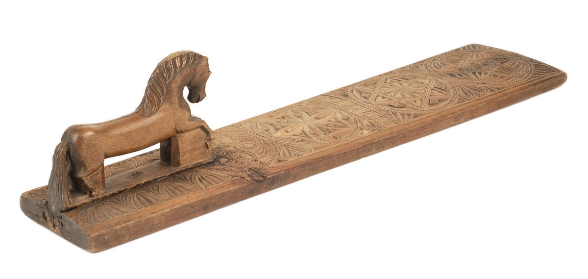 Mangletreets håndtak er utformet som en utskåret hest som står på bakken .  
Håndtaksidens overside på mangletreet har til dekor :
Utskåret karveskurd .