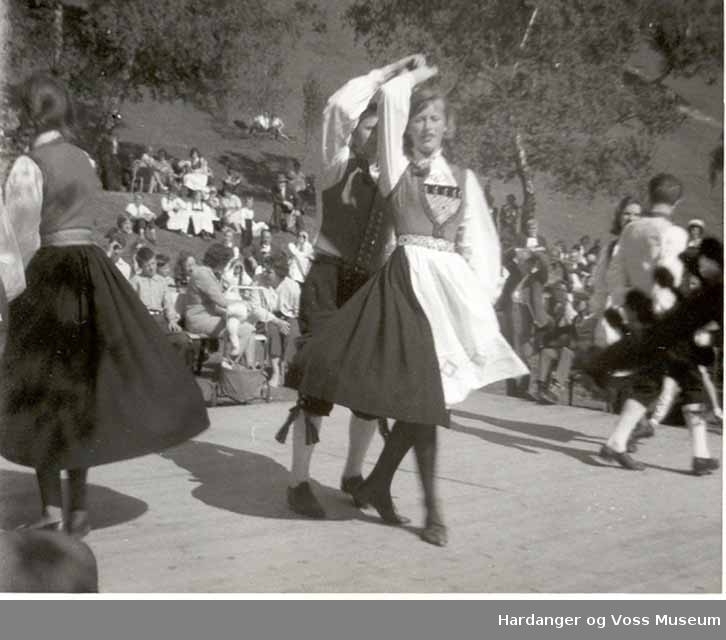 Gruppe, jenter, gutar, bunad, dans. Ungdomslagsstemna i Eidfjord, i Kinabyen