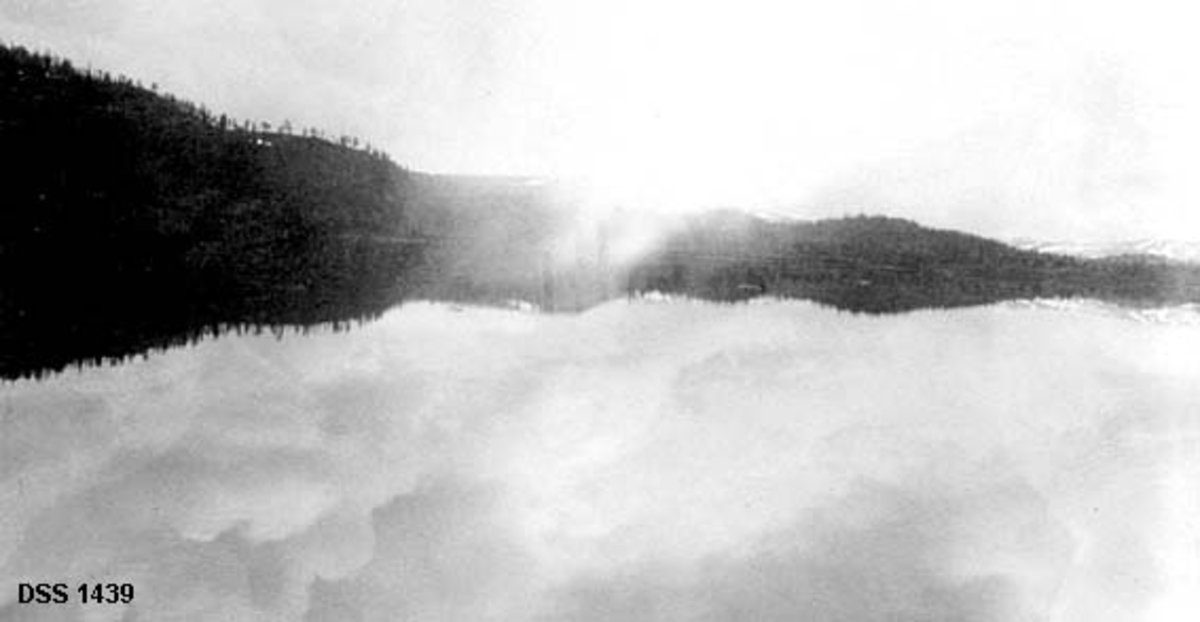 Fra Trekviltvatnet i Nordsjø privatallmenning i Stod.  Fotografiet viser hvordan en åsrygg med spredt skog speiler seg i det blanke vannspeilet. 