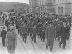 Hamar guttemusikkorps marsjerer fra jernbanestasjonen  i Tro