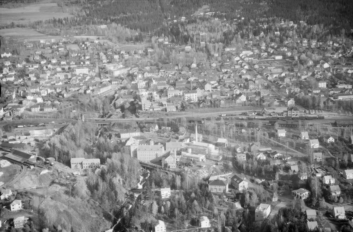 Flyfoto, Lillehammer, Gudbrandsdalens Uldvarefabrik AS, (ca.1951), mot Lillehammer sentrum. Jernbanestasjonen til høyre og jernbanen tvers over midten av bildet. Positivkopi med samme nr. 30688 har et annet motiv av fabrikken.