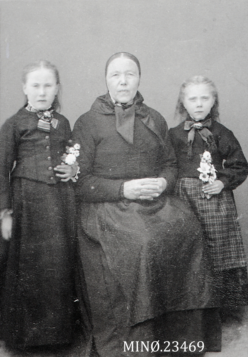 Portrett av eldre kvinne med to unge jenter