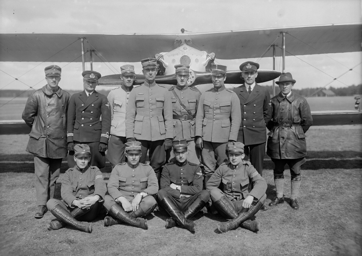 Grupporträtt. Stridsflygskolan på Malmen år 1927. Tolv män uppställda framför ett flygplan.