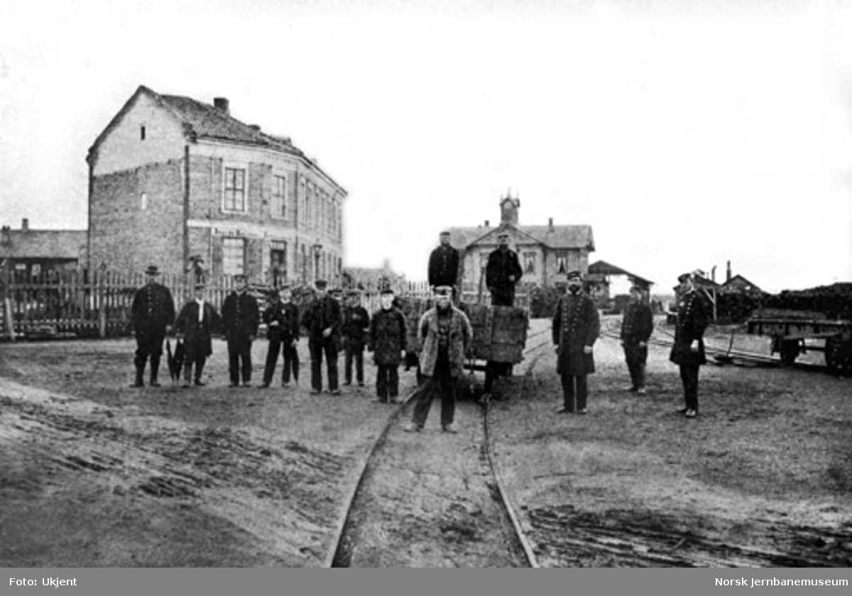 Personalet på Hamar stasjon oppstilt foran en vogn på bryggesporet med stasjonsbygningen i bakgrunnen