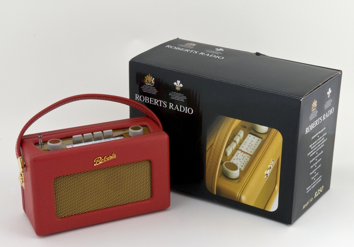 Rød, bærbar batteridrevet radio. Med svart batterilader. Ubrukt.