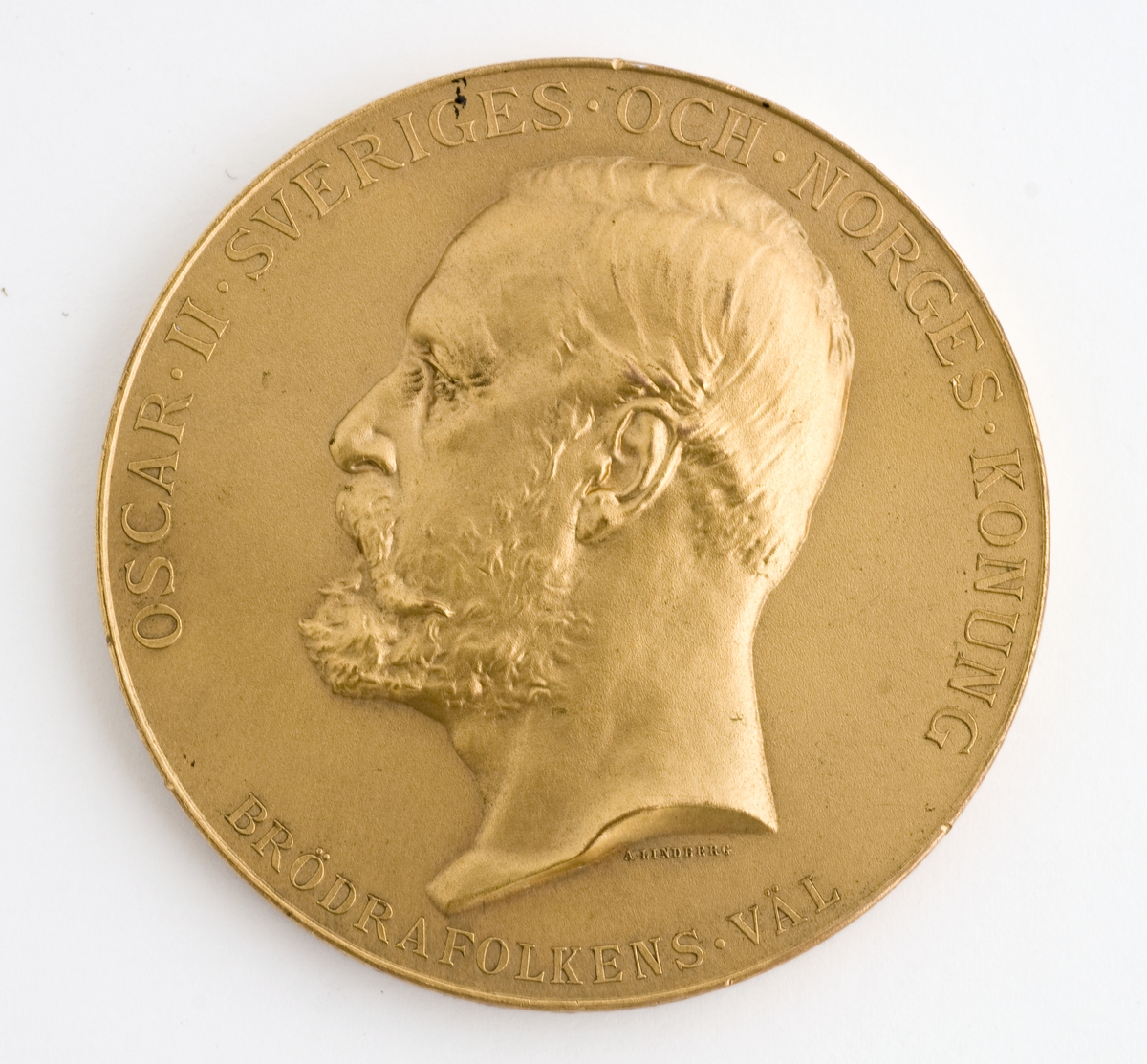 Rund medalje i etui. Kong Oscar IIs portrett i profil og hans valgspråk "BRÖDRAFOLKENS VÄL".