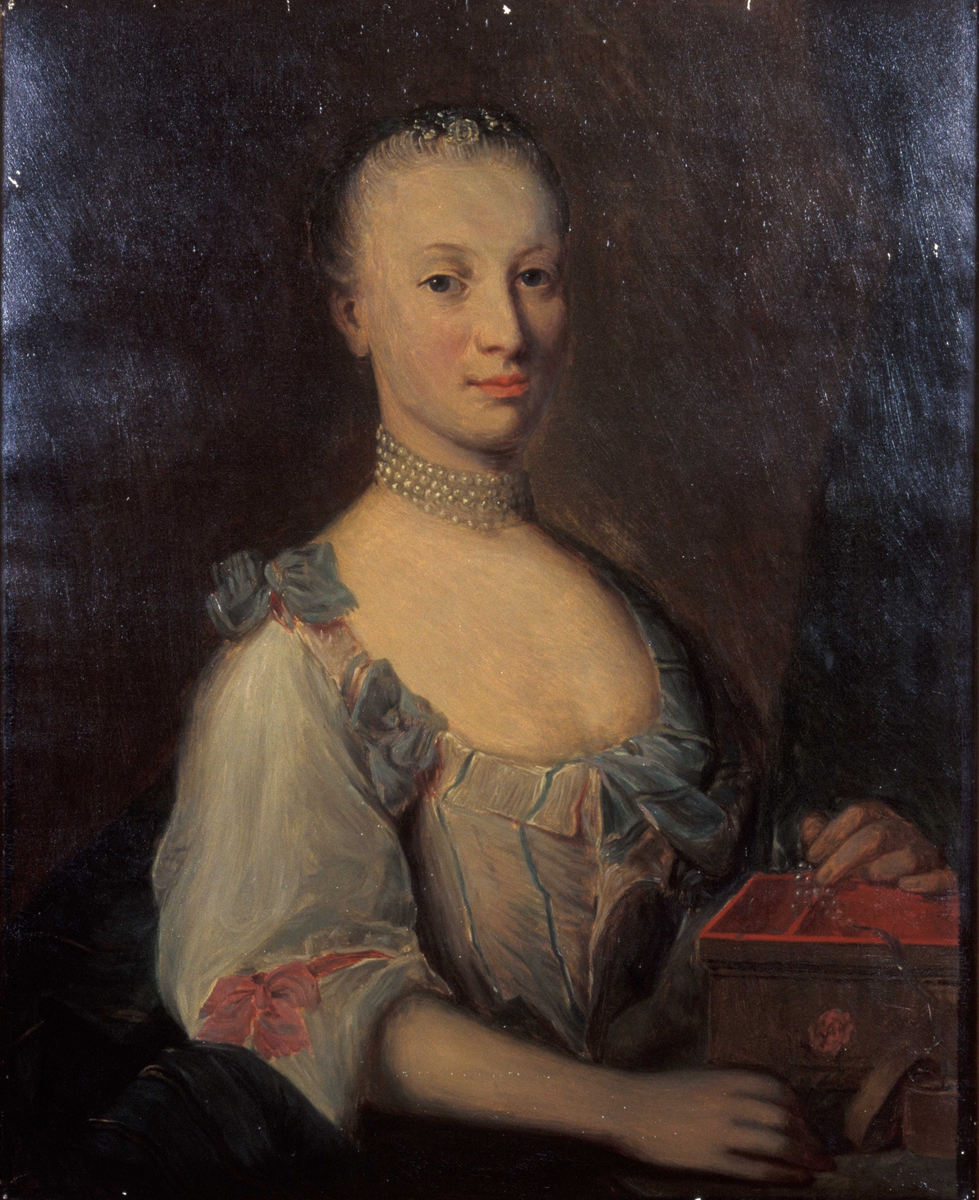 Kvinneportrett, halvfigur. Jacobine Chrystie (1746-1818) iført utringet, sløyfepyntet kjole og 4-raders perlehalsbånd. Tilbakestrøket hår.