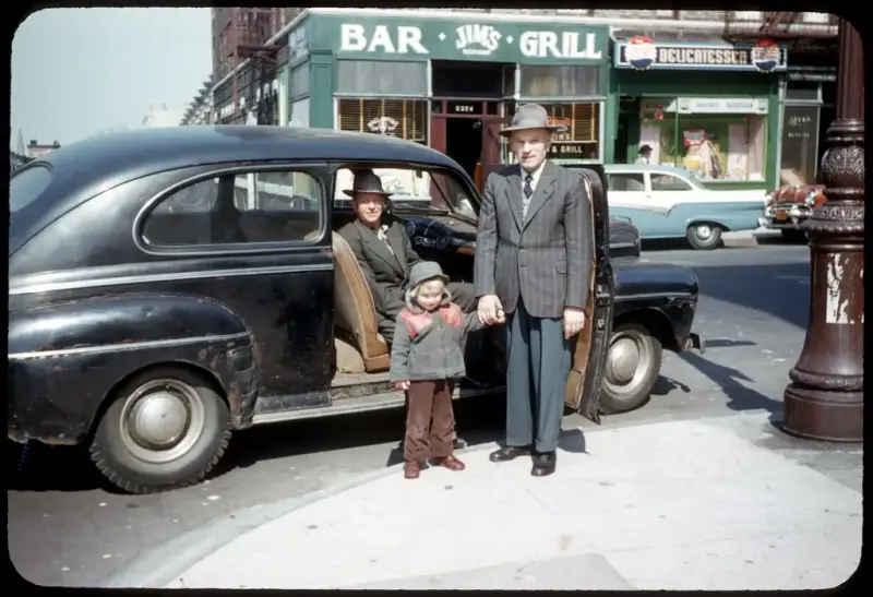 Three generations of Norwegians by a car on Lapskaus Boulevard in New York.