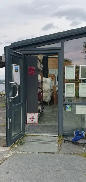 Hovudinngang på Lyngheisenteret med open dør. Døra er  i glas og metall og er opninga er 85 cm brei.