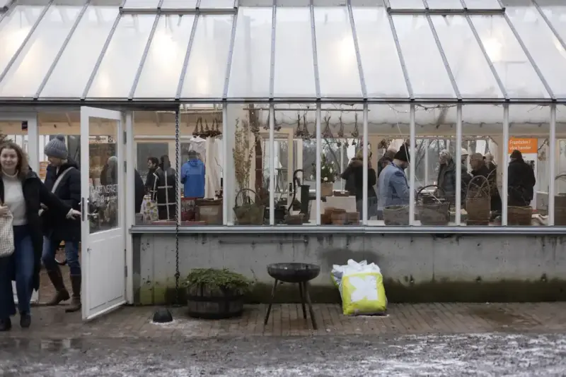 Gartneriet på Bygdø Kongsgård. Inne kan man se mennesker som handler fra markedsboder. 